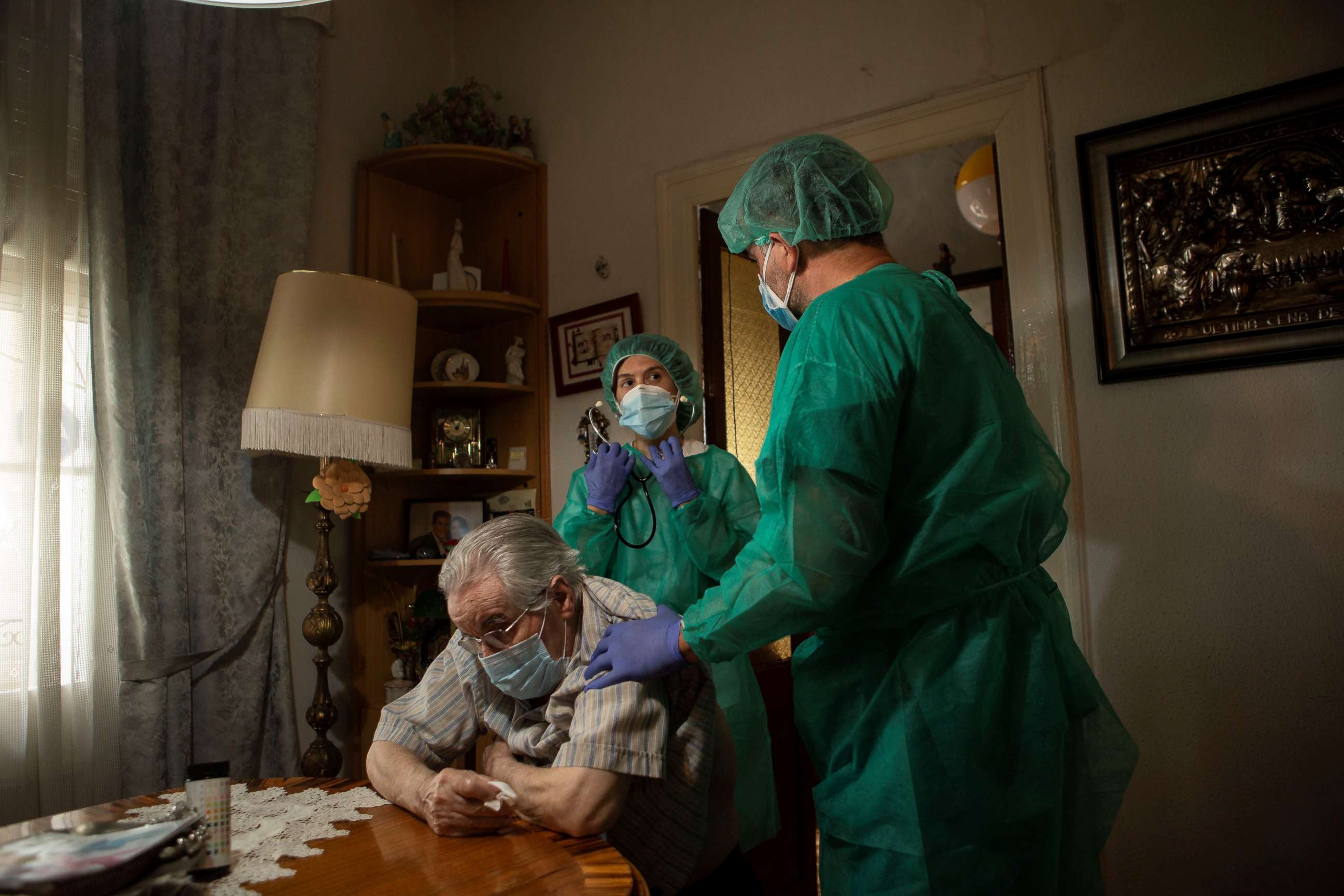 PHOTO: Medical personnel care for a patient during a house call visit in Barcelona, Spain, May 23, 2020. These home services during the Covid-19 pandemic provide tests and care to people with low mobility or on isolation.