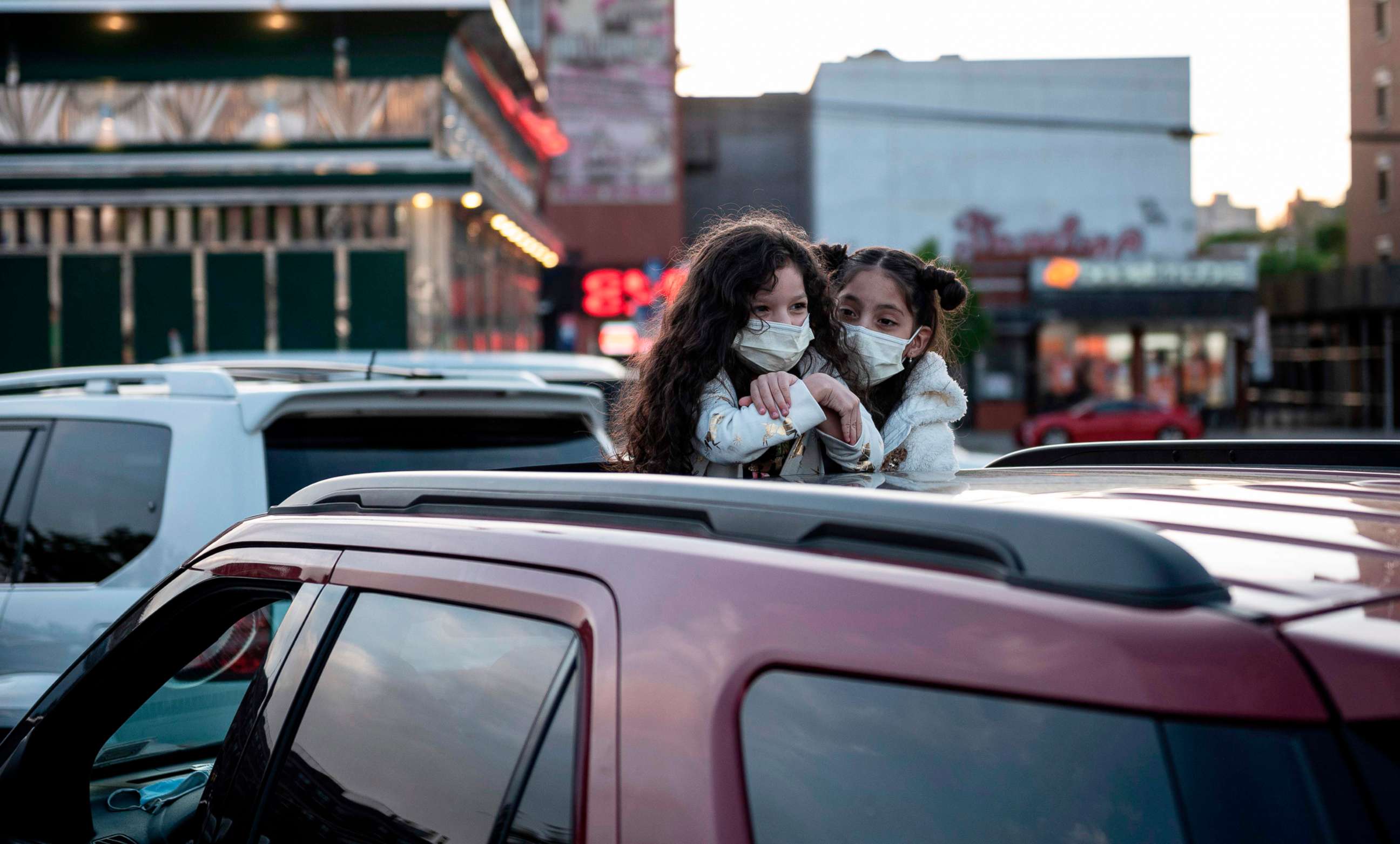 PHOTO: Two girls await a popup drive-in movie night at Bel Air Diner, May 20, 2020, in Queens, New York. The retro diner, which opened 1965, set up the drive-in cinema on its parking lot and shows movies once a week during the Covid-19 pandemic.