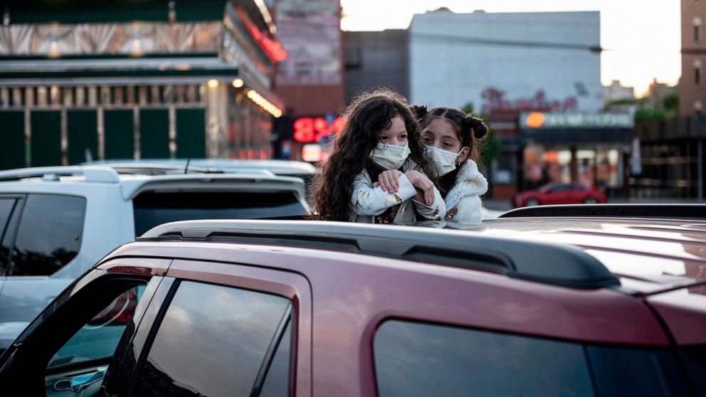 PHOTO: Two girls await a popup drive-in movie night at Bel Air Diner, May 20, 2020, in Queens, New York. The retro diner, which opened 1965, set up the drive-in cinema on its parking lot and shows movies once a week during the Covid-19 pandemic.