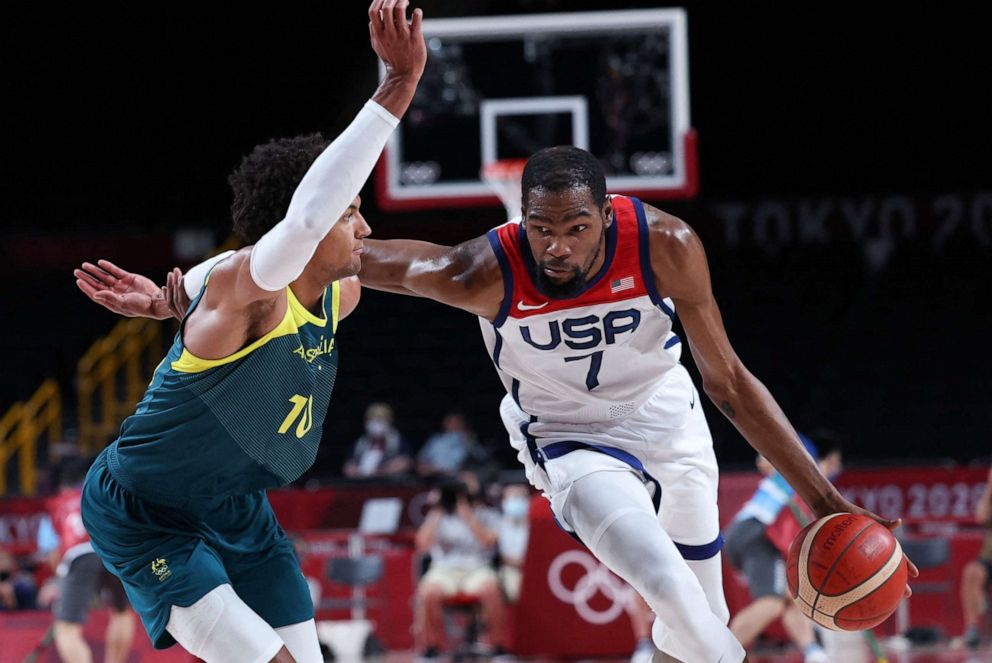 PHOTO: Kevin Durant dribbles the ball past Australia's Matisse Thybulle in the men's semi-final basketball match between Australia and USA during the Tokyo 2020 Olympic Games on Aug. 5, 2021.