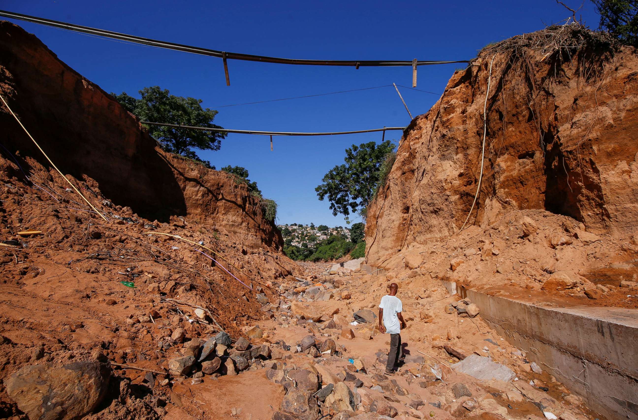 PHOTO: A man walks below a bridge which was destroyed after heavy rains caused flooding in Ntuzuma near Durban, South Africa, April 20, 2022.