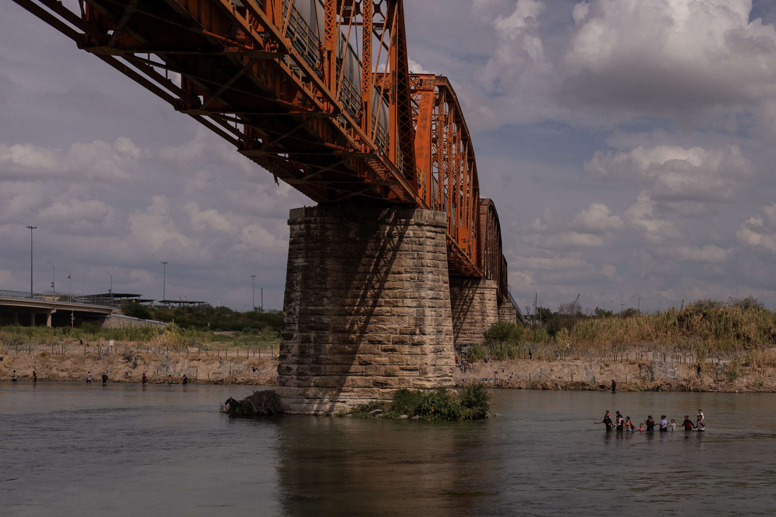 PHOTO: Migrants wade past the Puente Negro Ferrocarril train bridge while navigating the Rio Grande river for an entry point into Eagle Pass, U.S. as seen from Piedras Negras, Coahuila, Mexico, September 15, 2023.