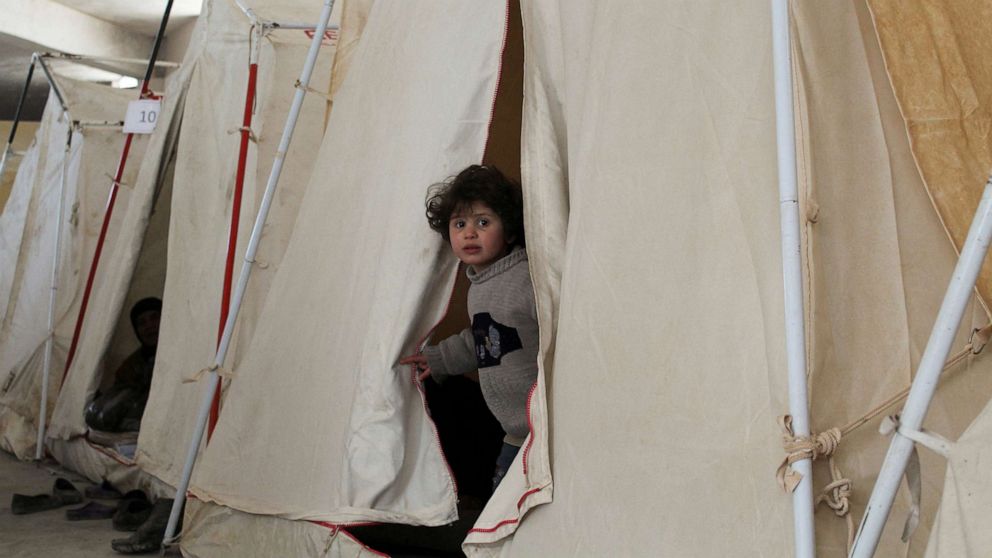 PHOTO: A child looks out of a tent, at a shelter in the aftermath of an earthquake, in Aleppo, Syria Feb. 10, 2023.