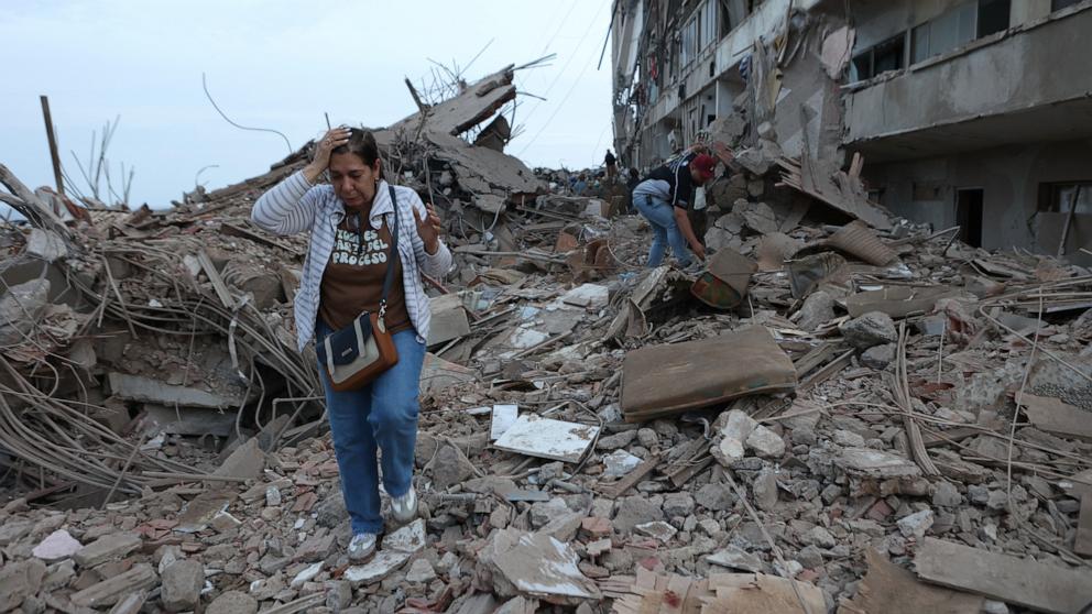 PHOTO: Residents walk among the rubble of building damaged in earthquakes the previous day in Catia La Mar, Venezuela, June 25, 2026. 