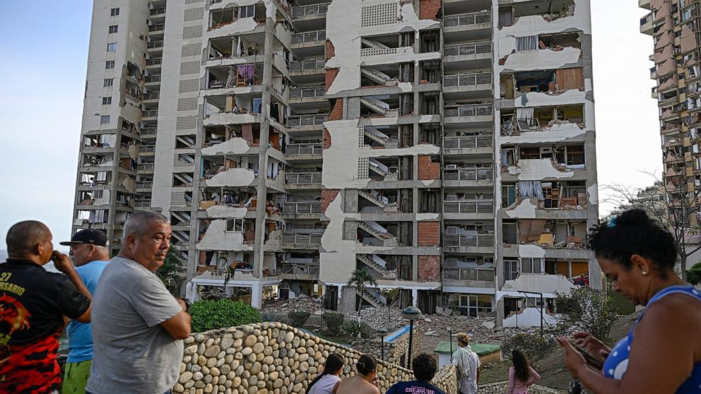 PHOTO: People stand before damaged apartment buildings following an earthquake in Catia La Mar, La Guaira state, some 30km north-west of Caracas, June 25, 2026. 