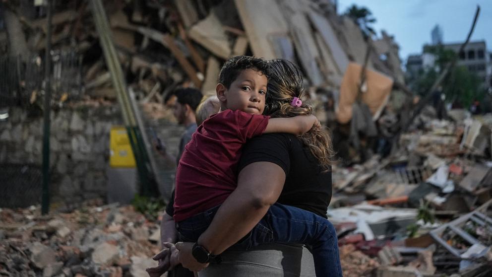 PHOTO: People walk past a collapsed building following an earthquake in Caracas, June 25, 2026. 