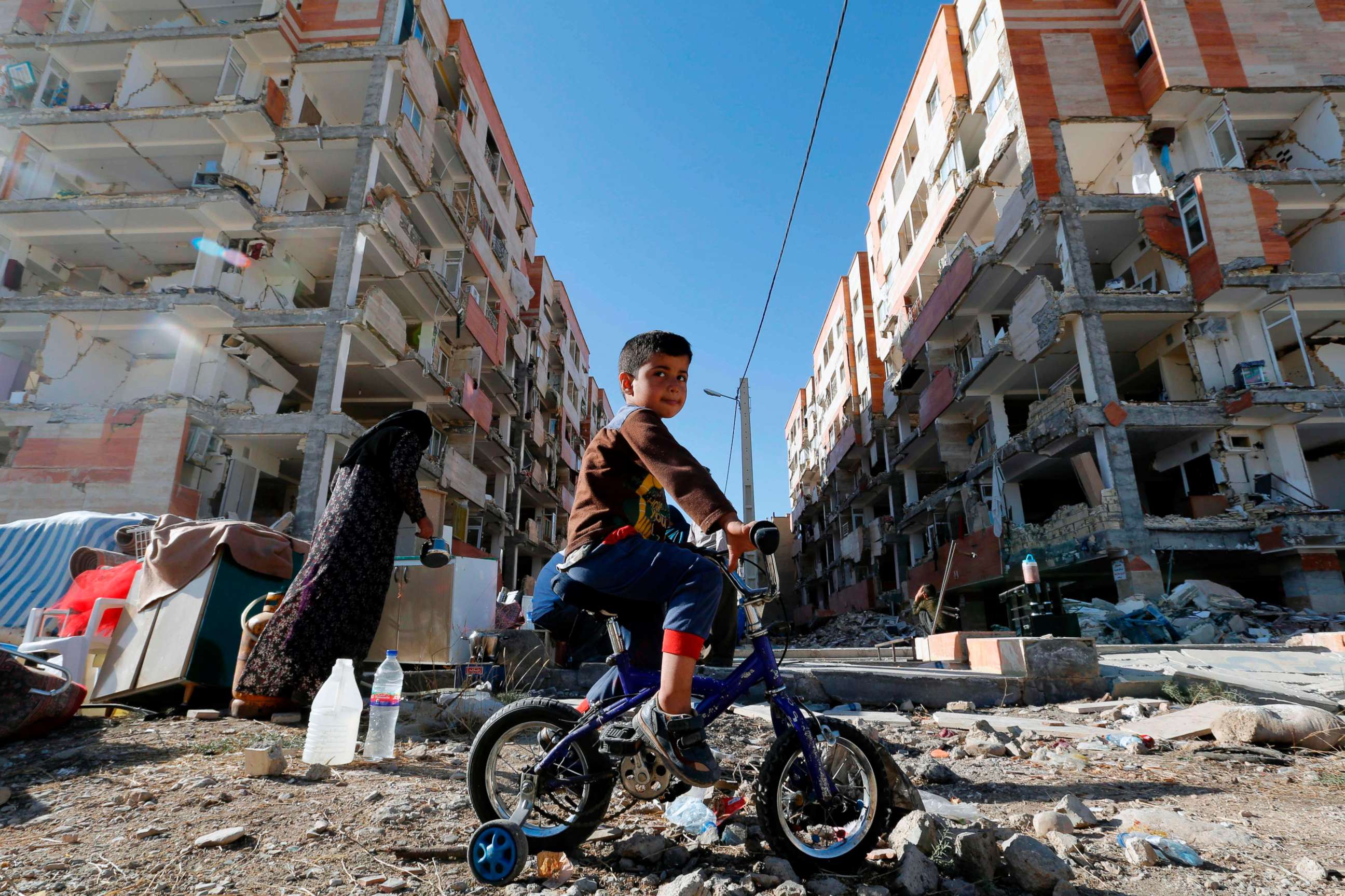 PHOTO: A boy rides a bicycle past earthquake damaged buildings in the town of Sarpol-e Zahab in Iran's western Kermanshah province near the border with Iraq, Nov. 14, 2017. A powerful earthquake struck the region on Nov. 12. 