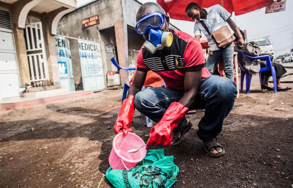 PHOTO: A health worker wears  protective gear and mixes water and chlorine in Goma on July 31, 2019.