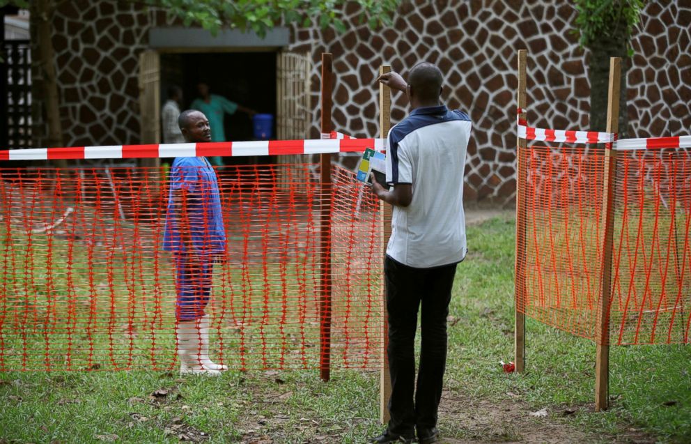 PHOTO: A resident speaks to a medical worker through a cordon ribbon, near the isolation facility prepared to receive suspected Ebola cases, at the Mbandaka General Hospital, in Mbandaka, Democratic Republic of Congo, May 20, 2018.