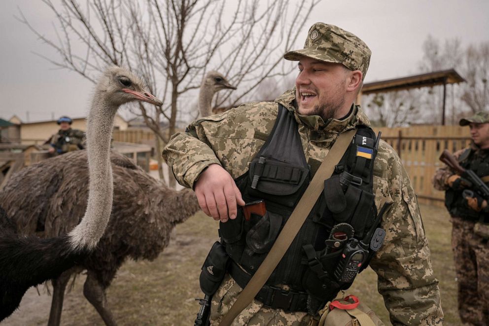 PHOTO: A Ukrainian serviceman tries to avoid being bitten by an ostrich at a heavily damaged private zoo as soldiers and volunteers attempted to evacuate the surviving animals to safety in the village of Yasnohorodka, Ukraine, March 30, 2022.