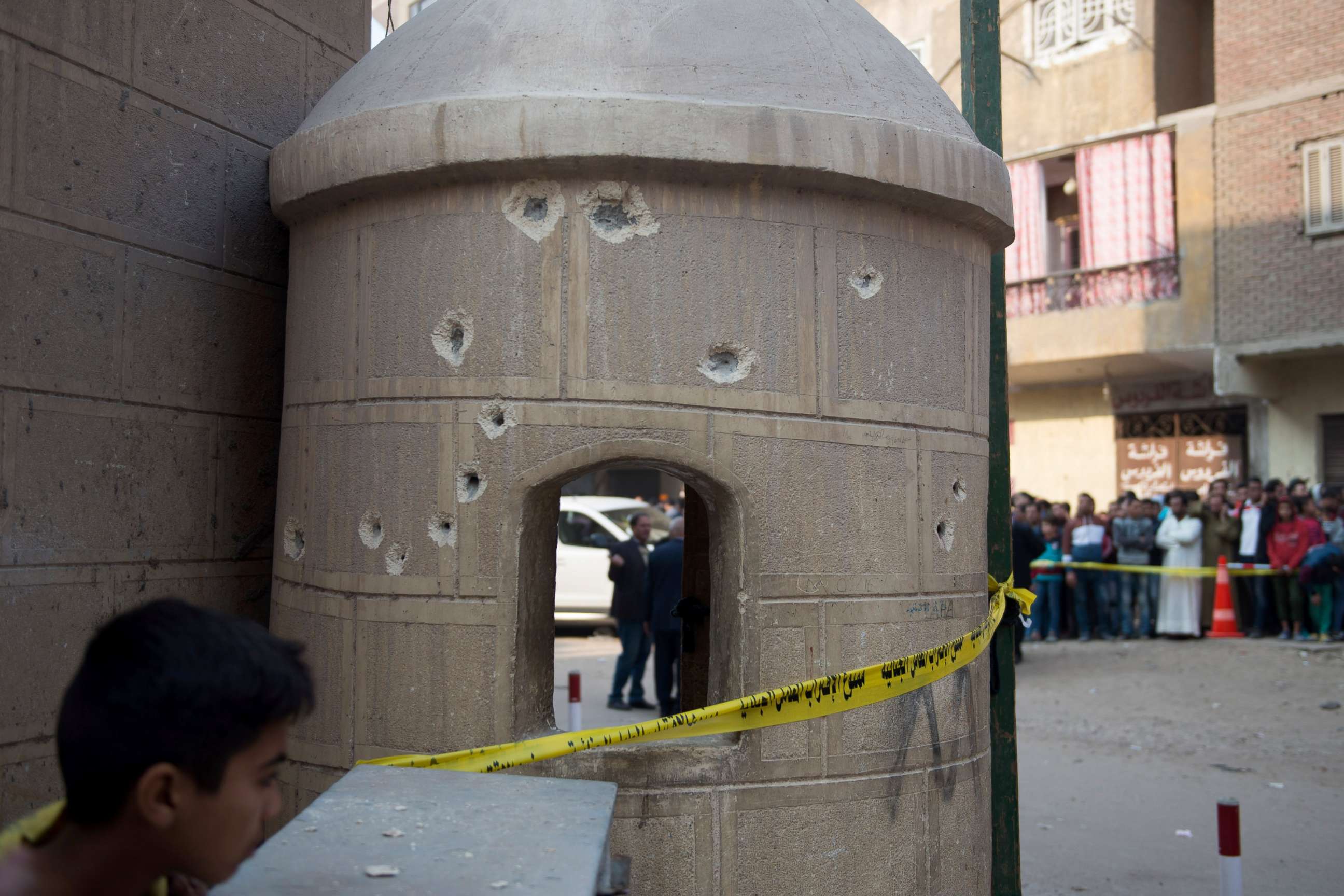 PHOTO: People stand near construction with bullet holes outside Mar Mina church following an attack on the church in the district of Helwan, southeastern Cairo, Dec. 29, 2017. 