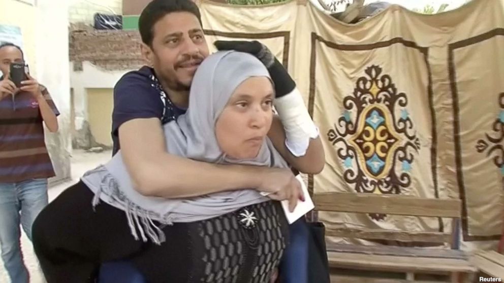 PHOTO: Heba Ragab carried her sick husband, Khaled al-Badawi, to vote in the Egyptian presidential election.