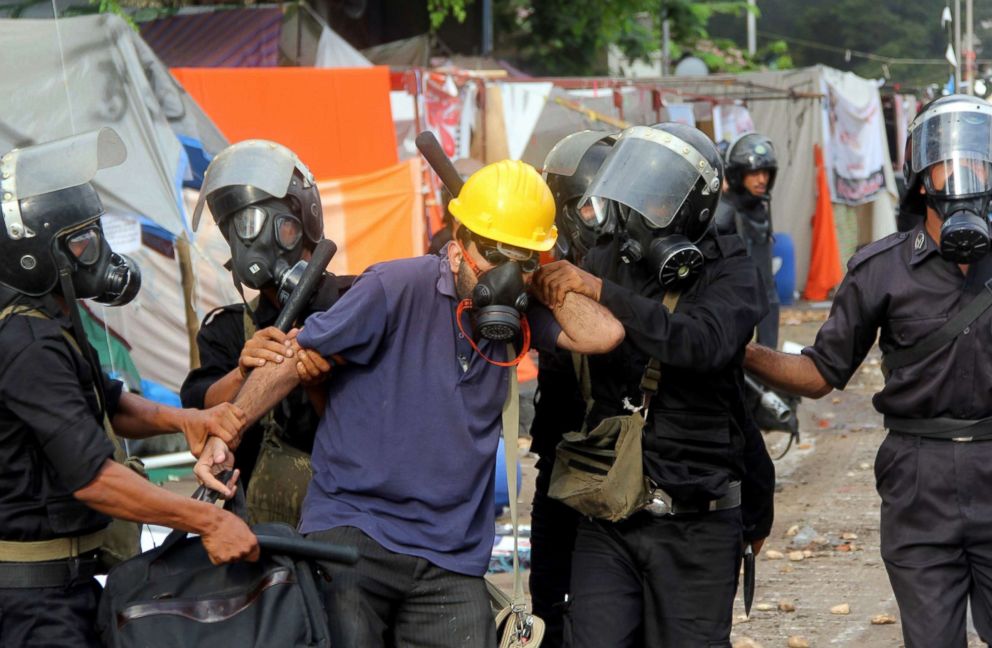 PHOTO: Egyptian riot police arrest a demonstrator during clashes as security forces backed by bulldozers moved in on two huge protest camps of supporters of Egypt's ousted president Mohamed Morsi, on Aug. 14, 2013, in Cairo.