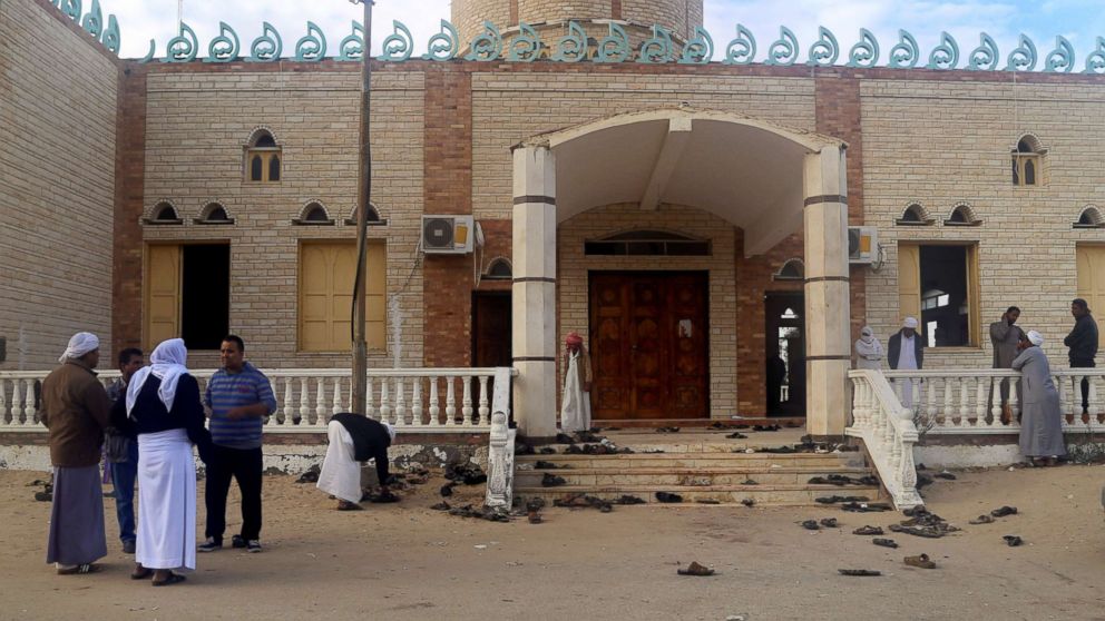 People stand outside Al Rawdah mosque, where a bomb exploded, in Bir Al-Abed, Egypt, Nov. 25, 2017. 