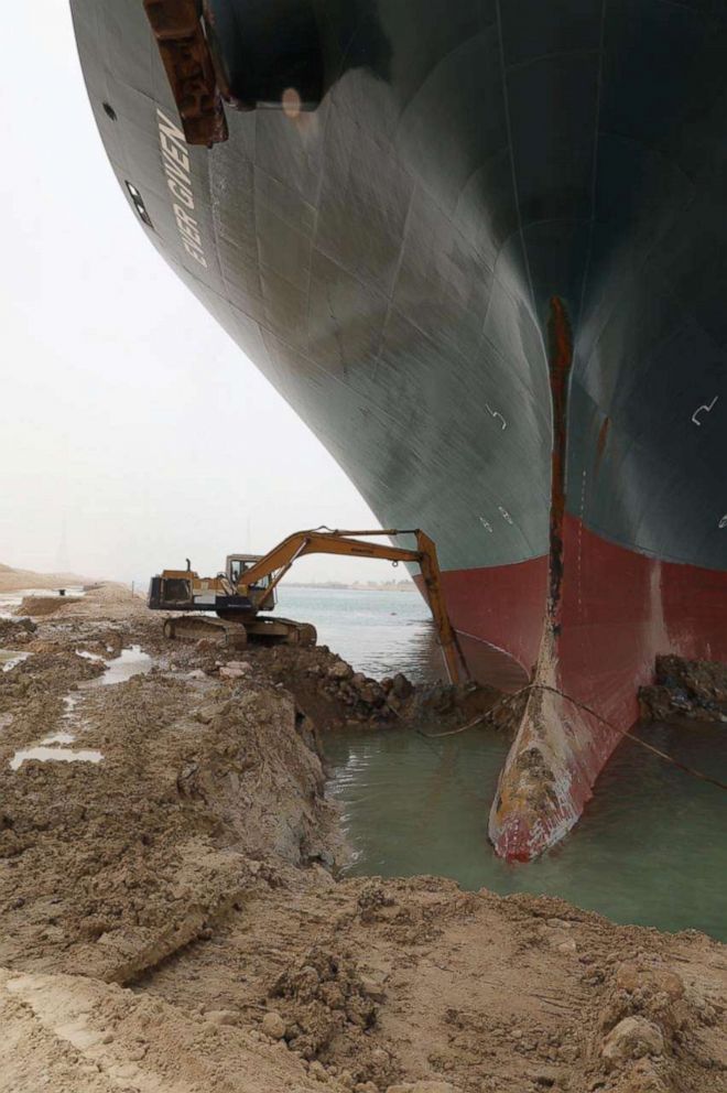 PHOTO: An excavator attempts to free stranded container ship Ever Given, one of the world's largest container ships, after it ran aground, in Suez Canal, Egypt March 25, 2021. 