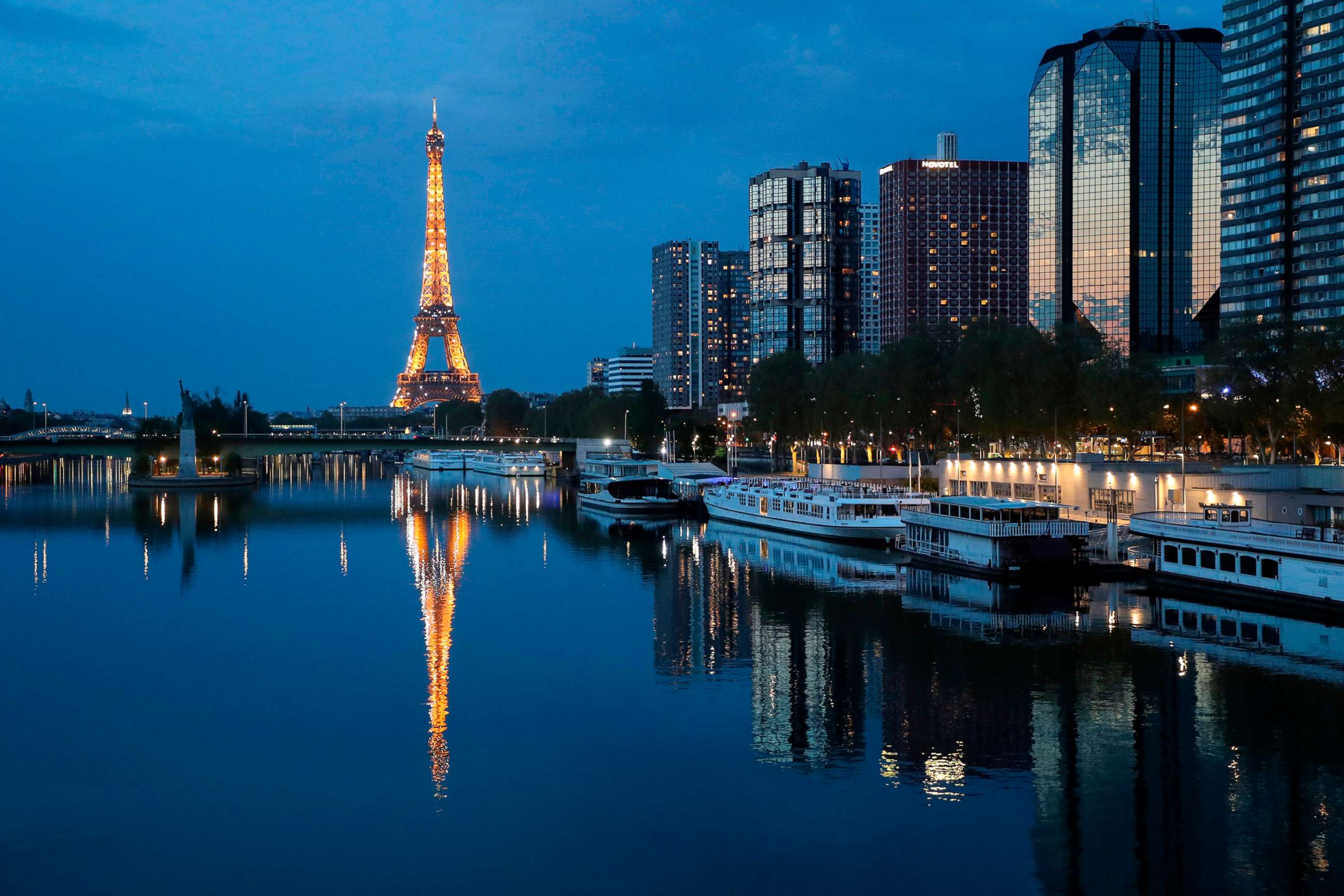 PHOTO: The illuminated Eiffel Tower is reflected on the Seine river at night in Paris, April 12, 2020.