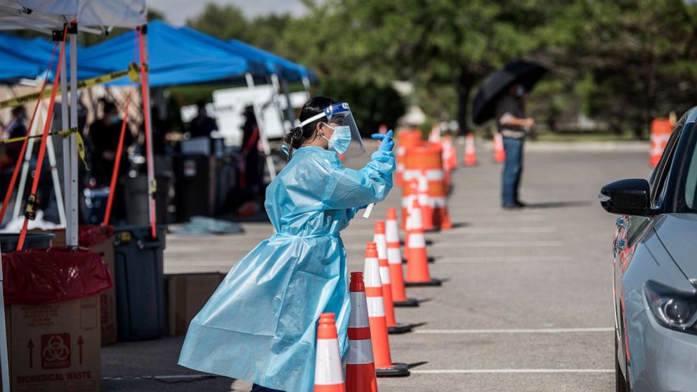 PHOTO: A nurse beckons to people in a car at a newly opened mega drive-thru site at El Paso Community College Valle Verde campus on July 21, 2020 in El Paso, Texas.
