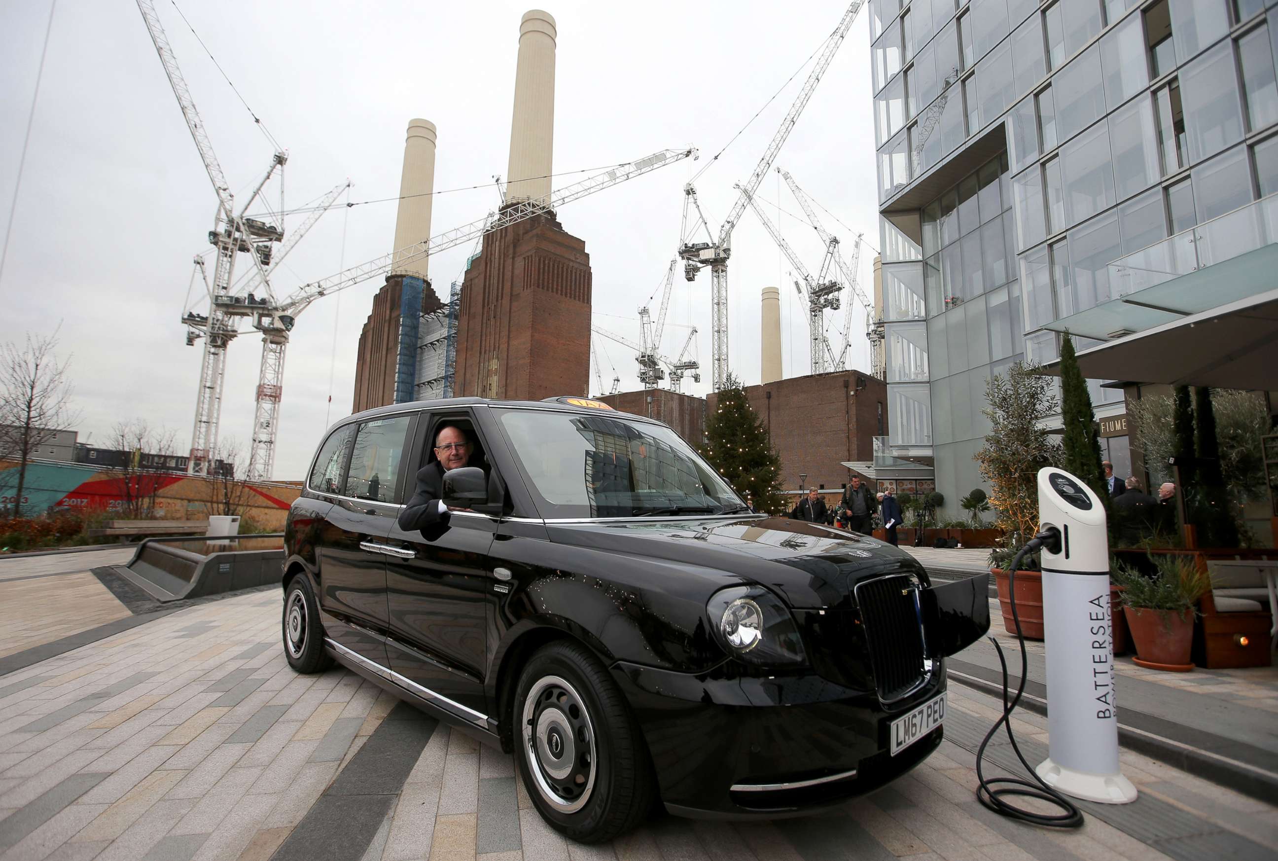 PHOTO: CEO of London EV Company, Chris Gubbey poses inside the new electric TX eCity taxi connected to a sample electric vehicle charger at the Battersea power station in London, Dec. 5, 2017.