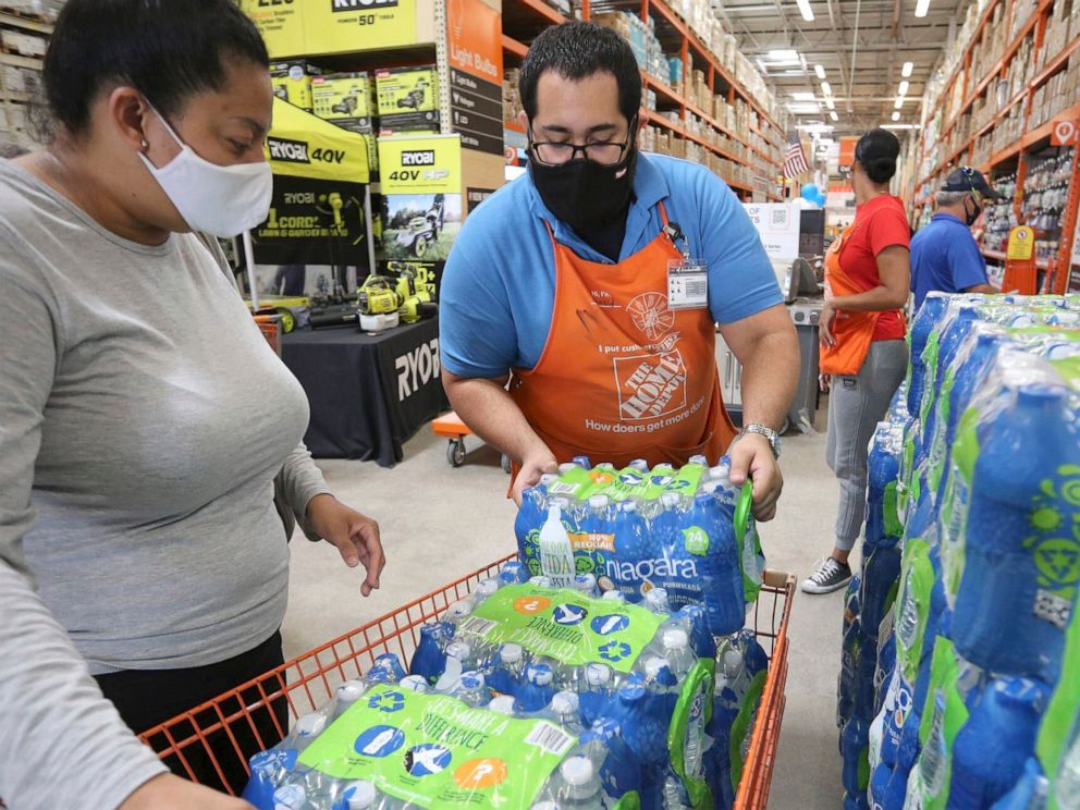 PHOTO: A Home Depot worker loads water bottles into a shopping cart as shoppers prepare for possible effects of tropical storm Elsa in Miami, July 3, 2021.