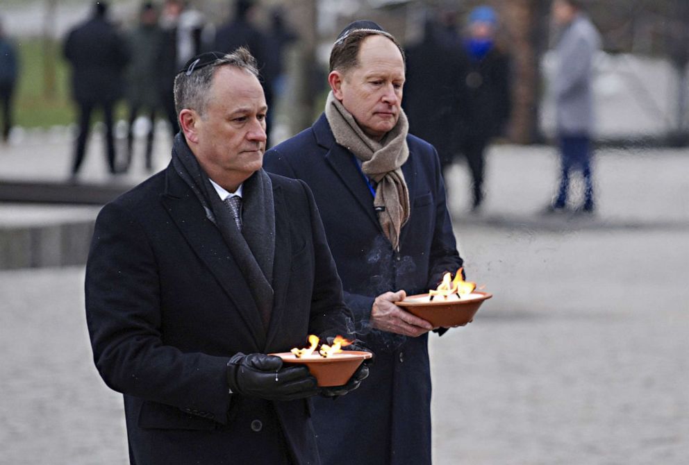 Second gentleman Douglas Emhoff, left, and U.S. Ambassador Mark Brzezinski hold candles during commemorations on the 78th anniversary of the liberation of the former German Nazi concentration and extermination camp, in Oswiecim, Poland on Jan. 27, 2023.