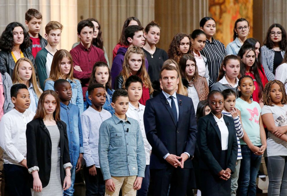 PHOTO: French President Emmanuel Macron stands with children in the nave of the Pantheon on April 27, 2018 in Paris, during a ceremony in tribute to the victims of French slavery in its colonies and celebrating 170 years since its abolition.