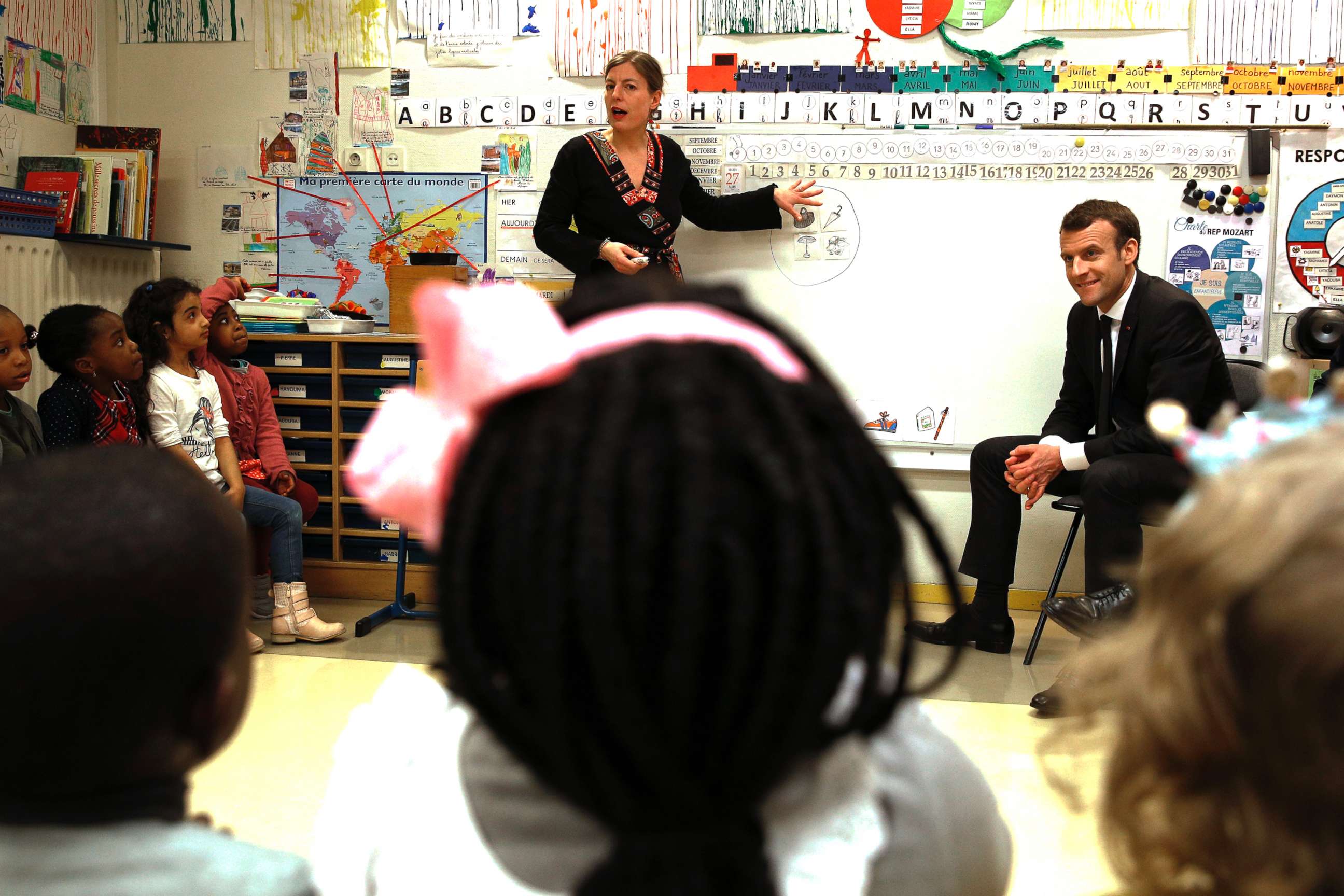 PHOTO: French President Emmanuel Macron listens to teacher Caroline Loret as he visits the Emelie pre-school in Paris, March 27, 2018.