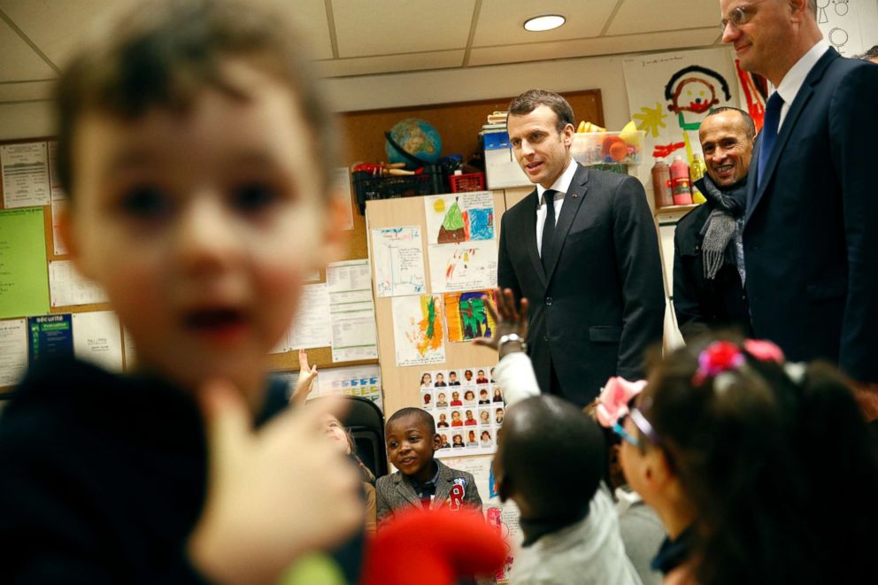 PHOTO: French President Emmanuel Macronand French Education Minister Jean-Michel Blanquer speak to preschool children as they visit the Emelie pre-school in Paris, March 27, 2018.