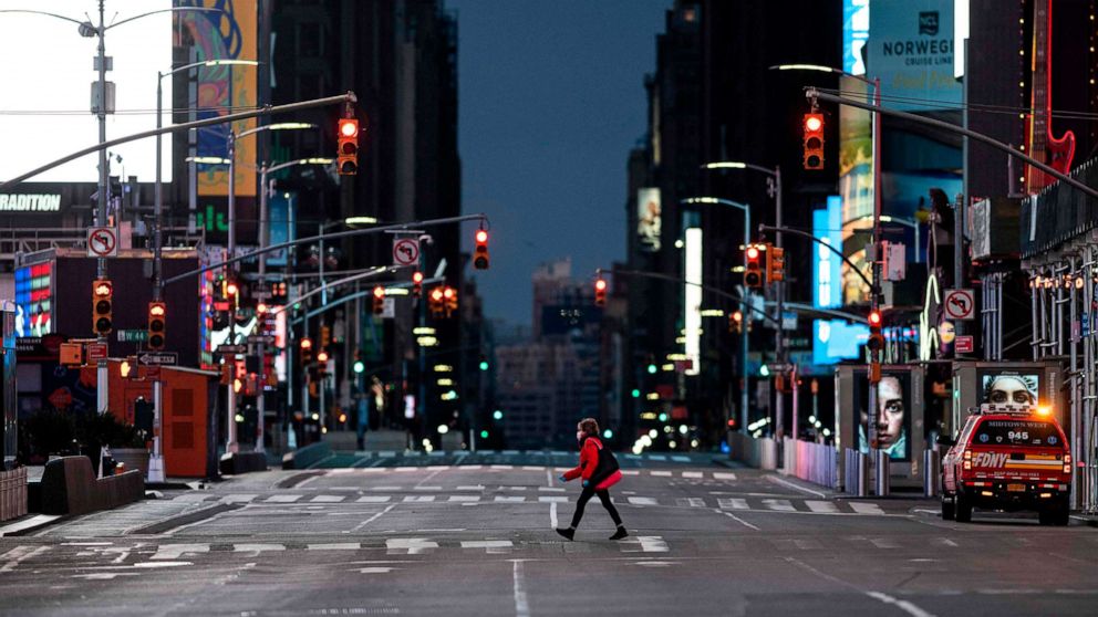 PHOTO: A woman walks through an almost-deserted Times Square in the early morning hours, on April 23, 2020, in New York City.