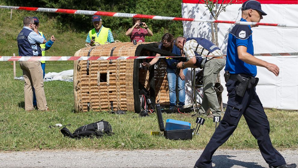 Swiss police officers inspect a hot air balloon after it crashed, in Montbovon near Chateaux d'OEx, Switzerland, Aug. 6, 2013.