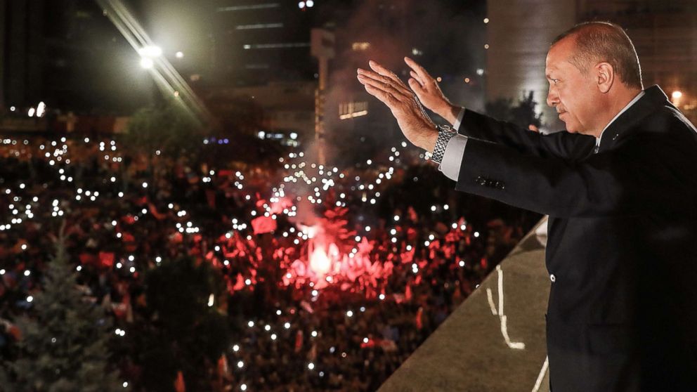 PHOTO: Turkish President Tayyip Erdogan waves to supporters gathered above a balcony at the headquarters of the AK Party in Ankara, June 24, 2018, as they celebrate Erdogan winning five more years in office.