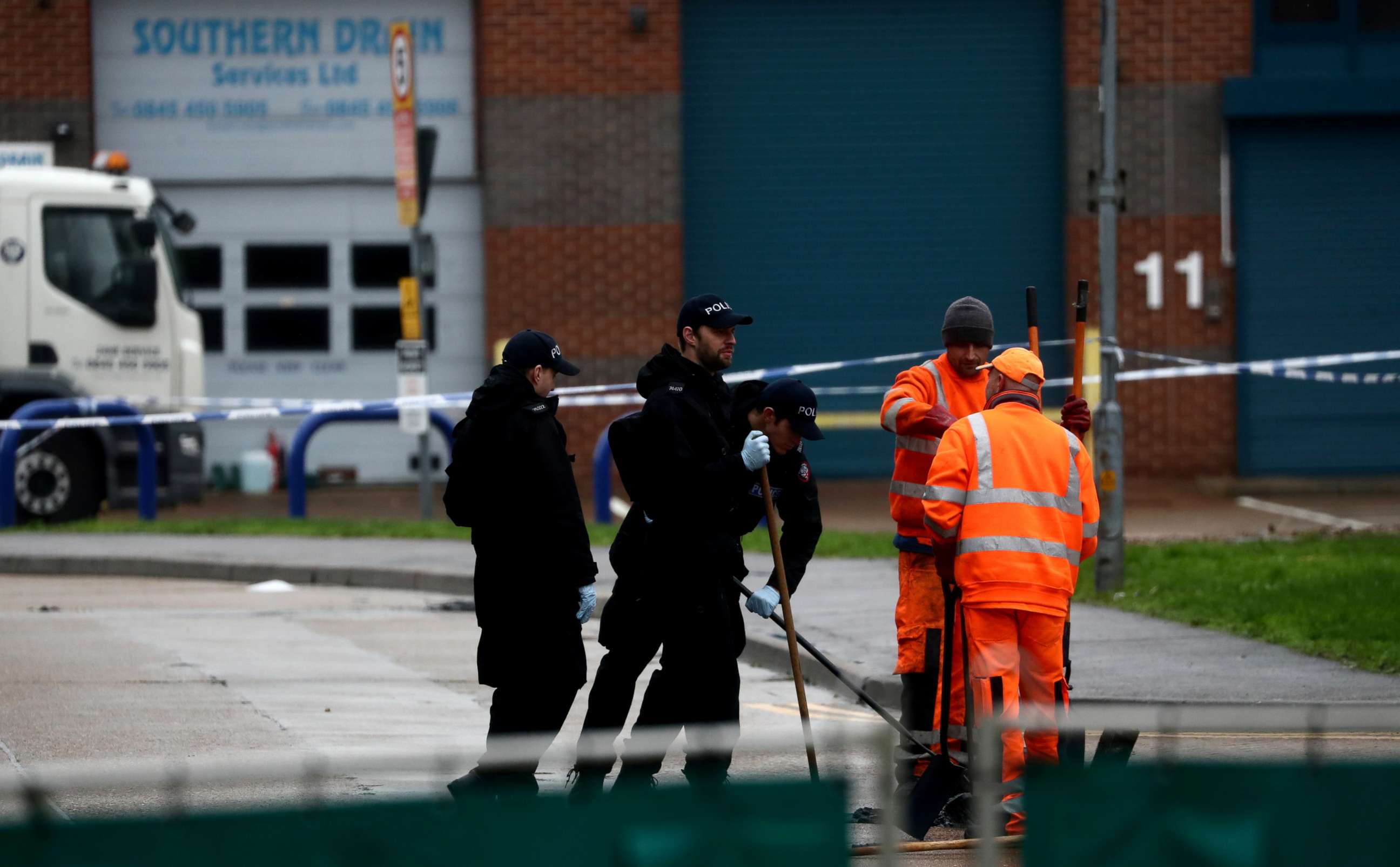 PHOTO: Police officers inspect a drain at the scene where bodies were discovered in a lorry container, in Grays, Essex, Britain October 24, 2019. 