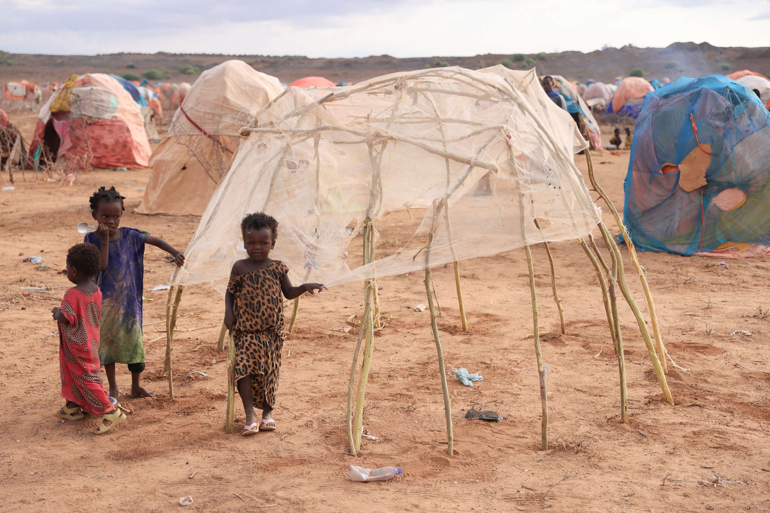PHOTO: In this April 27, 2022, file photo, children stand next to a makeshift shelter at the Higlo camp for people displaced by drought, in the town of Gode, Ethiopia.