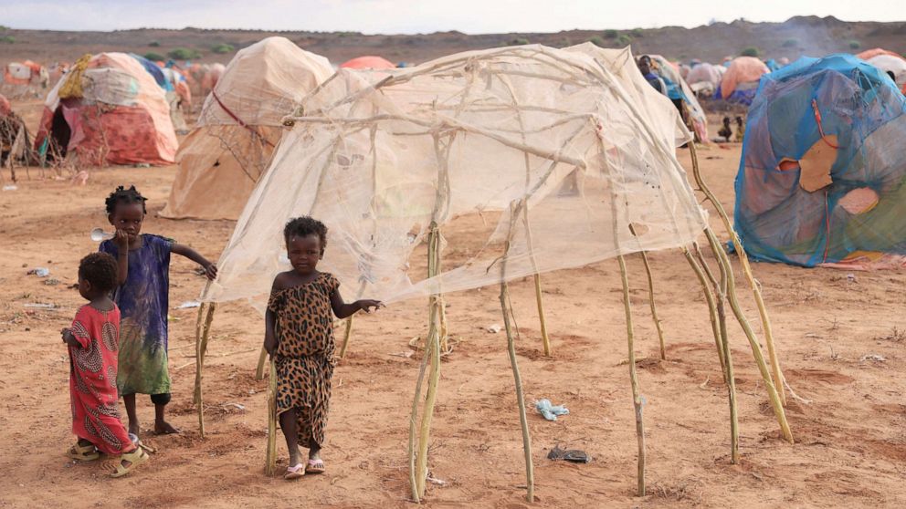 PHOTO: In this April 27, 2022, file photo, children stand next to a makeshift shelter at the Higlo camp for people displaced by drought, in the town of Gode, Ethiopia.