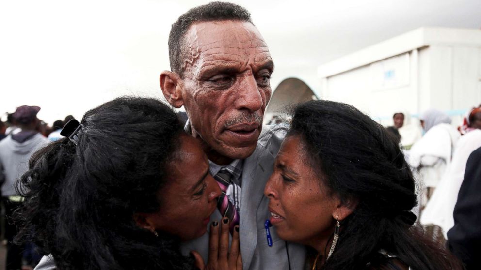 Addisalem Hadgu, reacts as he embraces his daughters, after meeting them for the first time in eighteen years, at Asmara International Airport in Asmara, Eritrea, July 18, 2018.