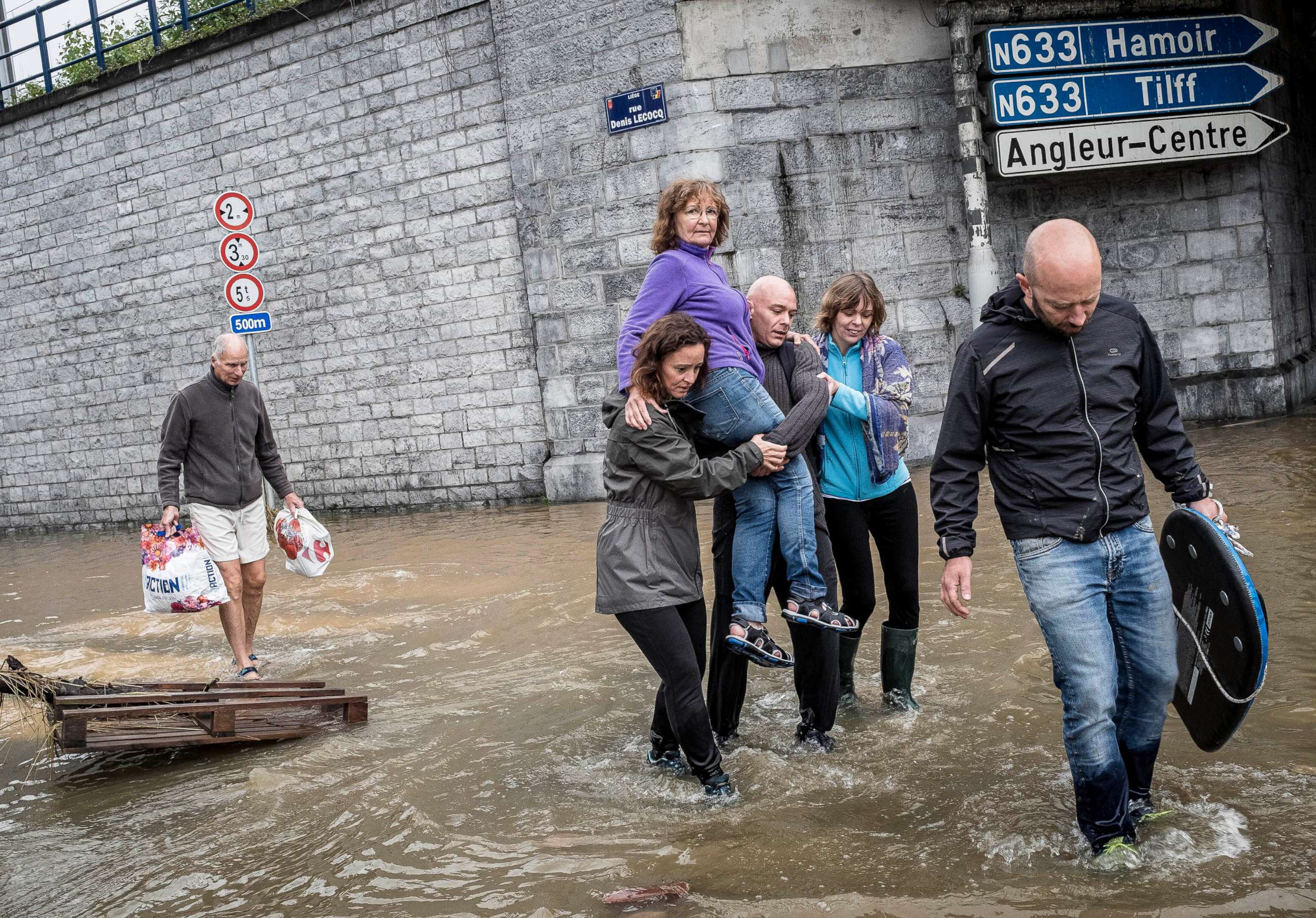PHOTO: A woman is carried through a flooded street in Angleur, Province of Liege, Belgium, July 16, 2021.