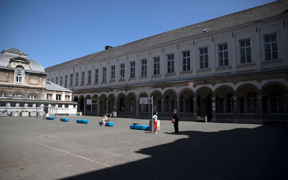 PHOTO: Teachers stand at a social distance from each other in the playground of the Royal Atheneum school, during the partial lifting of coronavirus, COVID-19, lockdown regulations in Antwerp, Belgium, May 18, 2020.