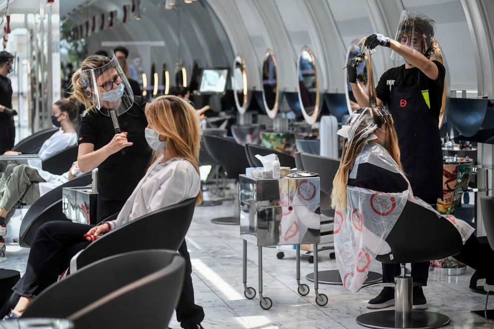 PHOTO: Clients get their hair done at a hairdresser in Milan, Italy, May 18, 2020 as Italy is slowly lifting sanitary restrictions after a two-month coronavirus lockdown.
