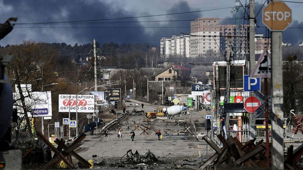 PHOTO: Residents evacuate the city of Irpin, north of Kyiv, March 10, 2022, as smoke rises in the distance.