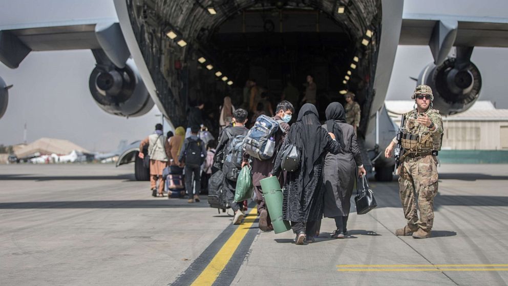 PHOTO: Families begin to board a U.S. Air Force C-17 Globemaster III transport plane during an evacuation at Hamid Karzai International Airport, Afghanistan, Aug. 23, 2021.