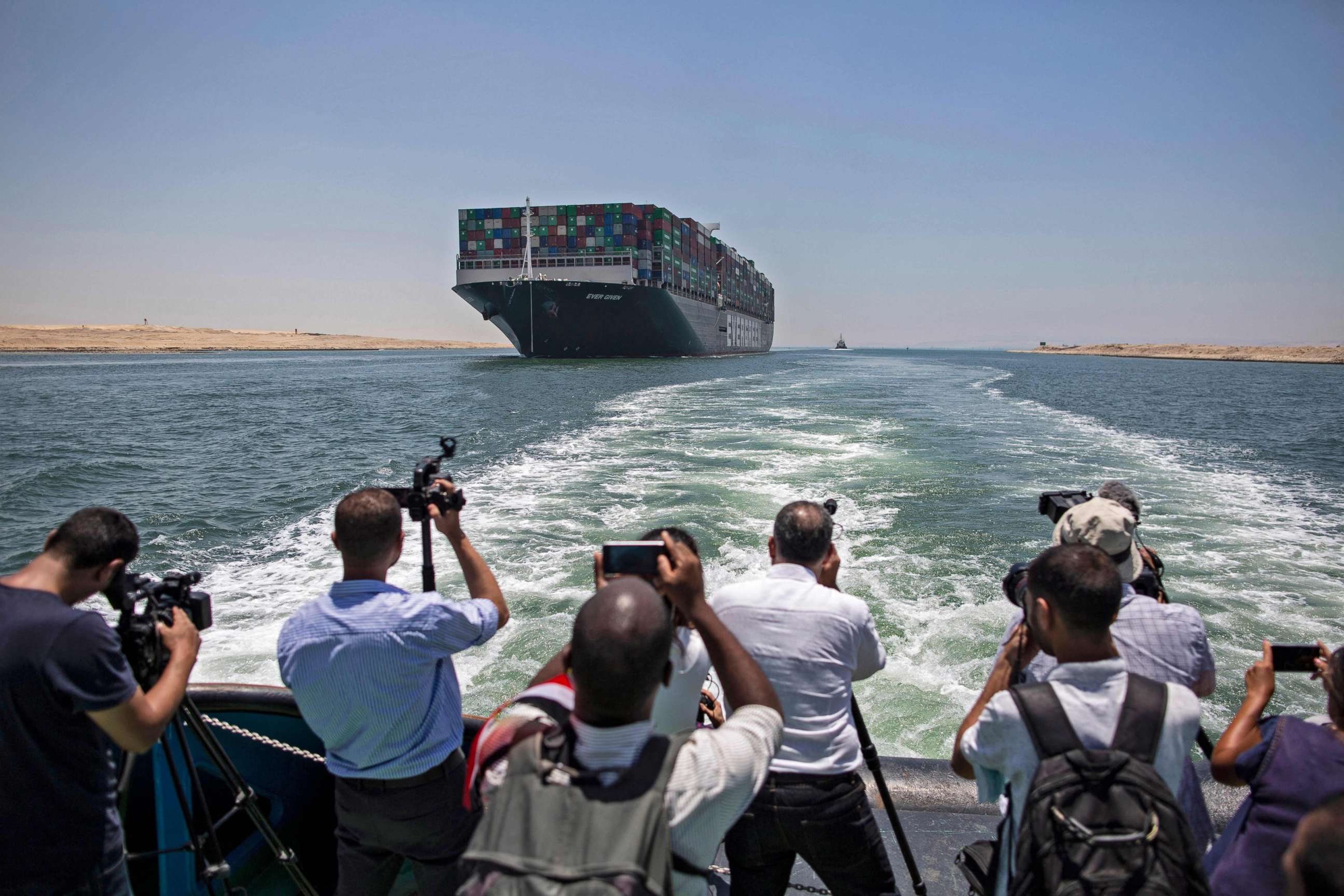 PHOTO: Journalists on a nearby boat film the Panama-flagged MV Ever Given container ship sailing along Egypt's Suez Canal near the canal's central city of Ismailia on July 5, 2021.