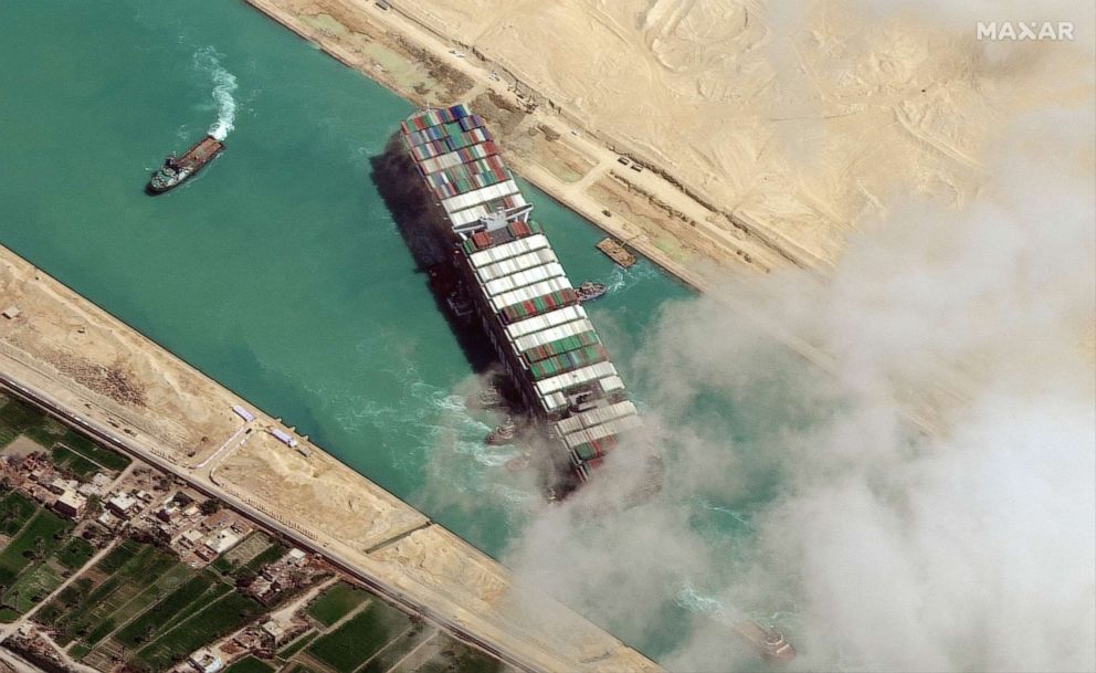 PHOTO: In this file satellite image released by Maxar Technologies on March 29, 2021, the MV Ever Given container ship being pushed by tugboats in the Suez Canal.