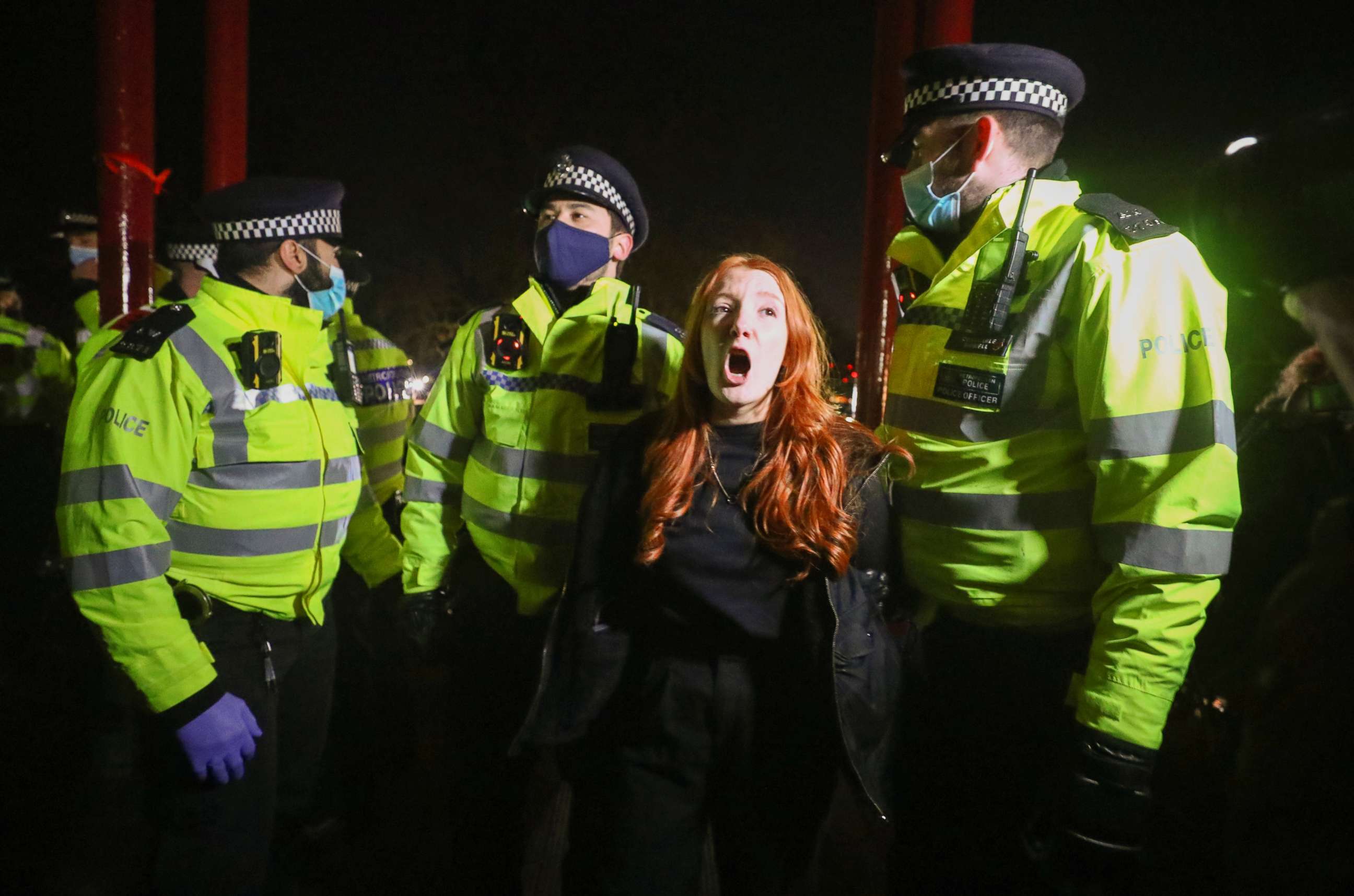 PHOTO: Police detain a woman as people gather at a memorial site in Clapham Common Bandstand, following the kidnap and murder of Sarah Everard, in London, on March 13, 2021.