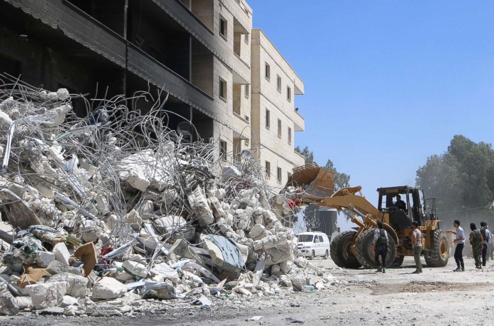 PHOTO: A tractor clears the rubble of destroyed buildings, Aug. 13, 2018, following an explosion at an arms depot in a residential area in Syria's northern Idlib province city of Sarmada in which dozens of people were reportedly killed.