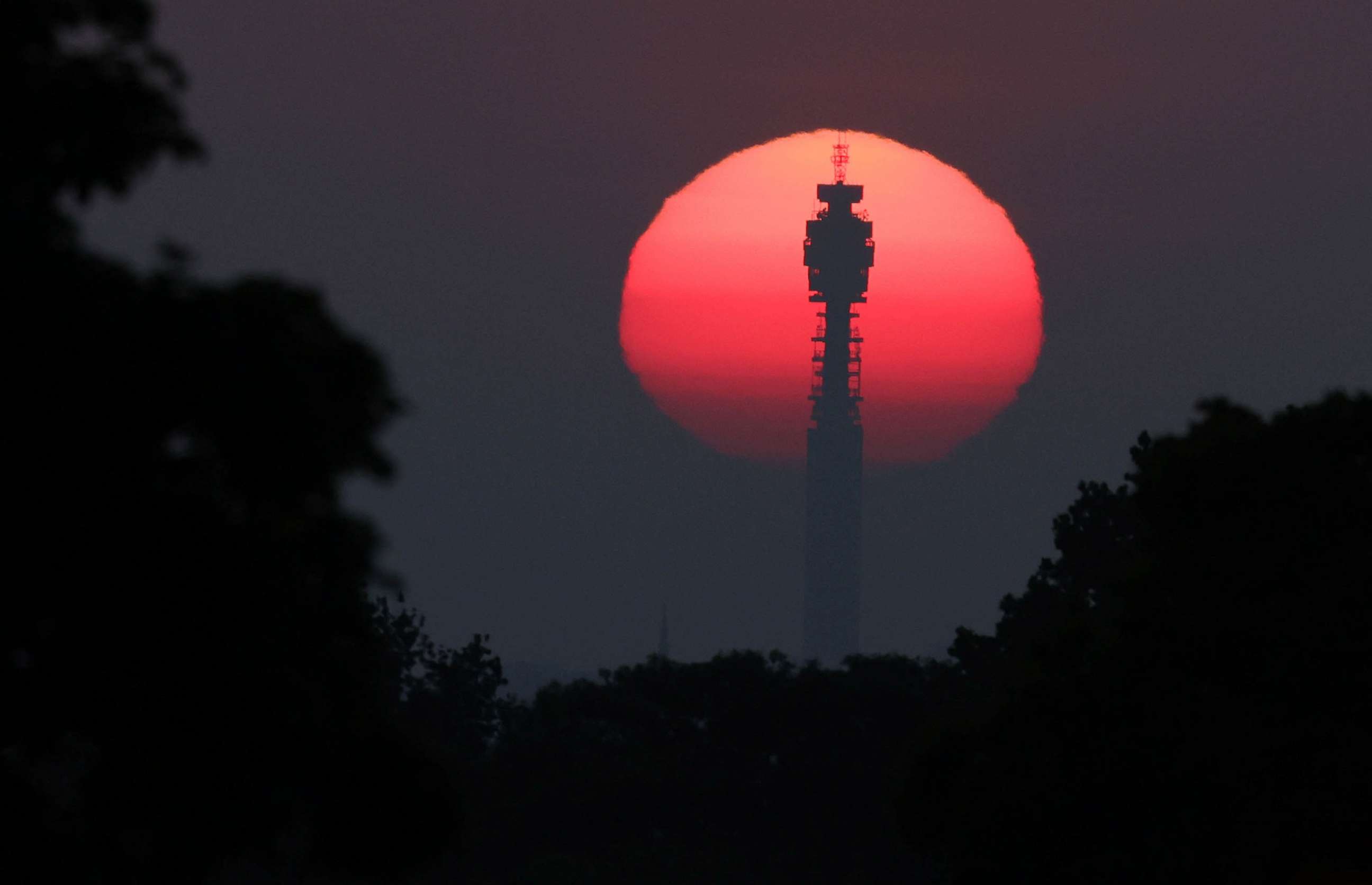 PHOTO: FILE - The sun rises behind the BT Tower, as hot weather continues, in London, June 10, 2023.