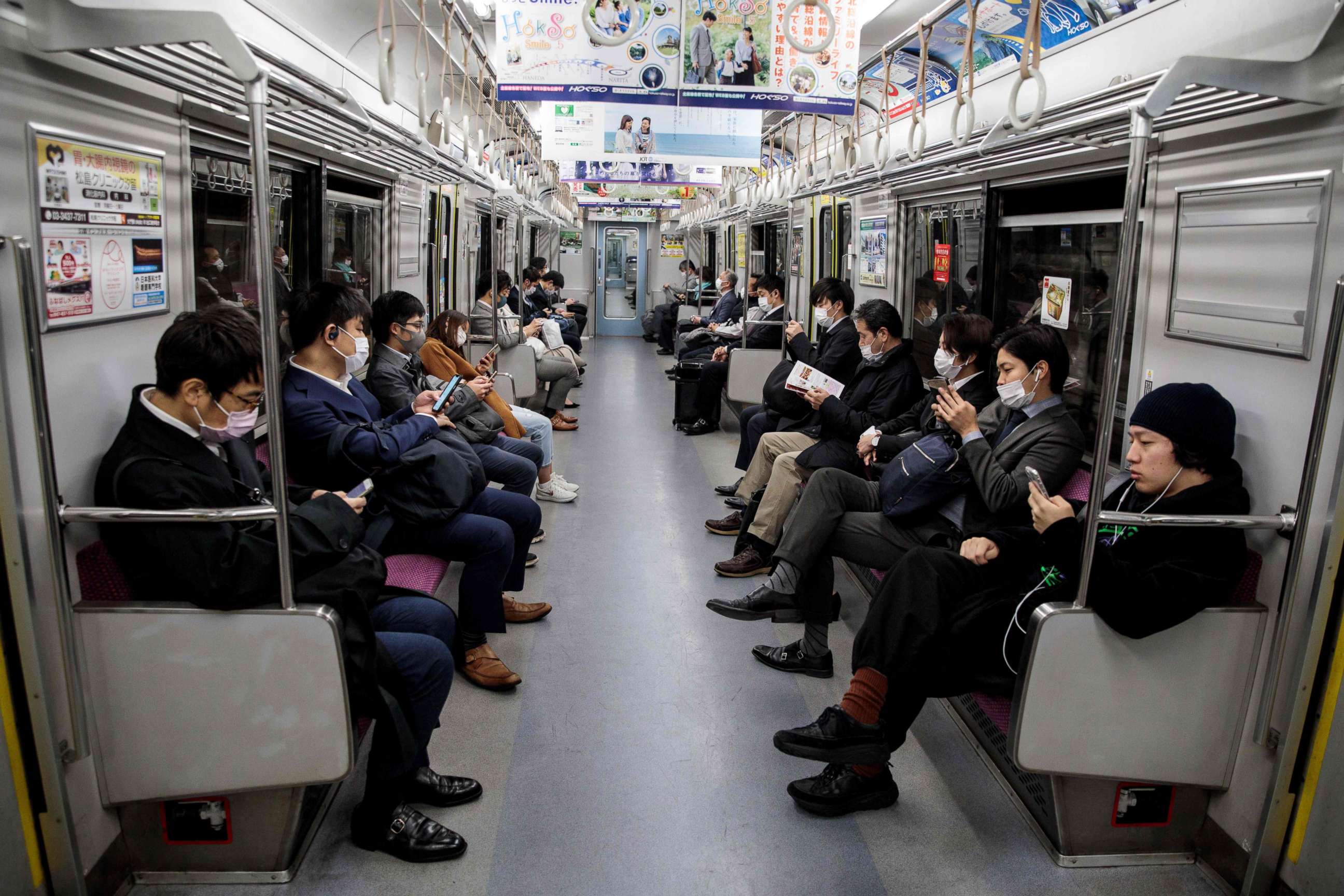 PHOTO: People wearing face masks amid concerns over the spread of the novel coronavirus commute on a train in Tokyo, Japan, on April 6, 2020.