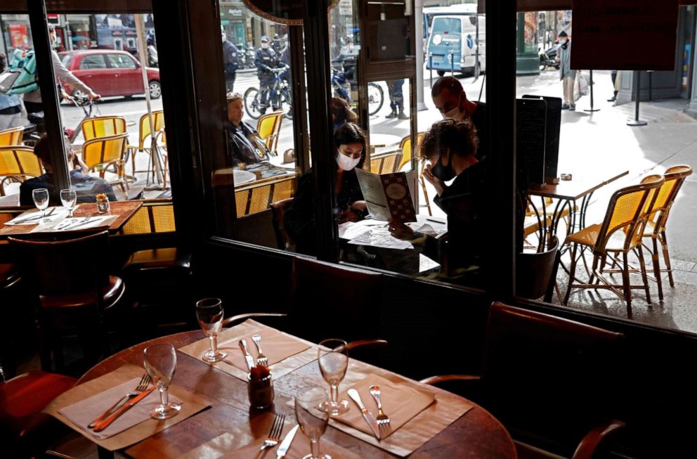 PHOTO: Customers wearing face masks order meals on the terrace of a restaurant in Paris, France, on Oct. 6, 2020, on the first day of reinforced restrictions aimed at curbing the spread of COVID-19 in the French capital.