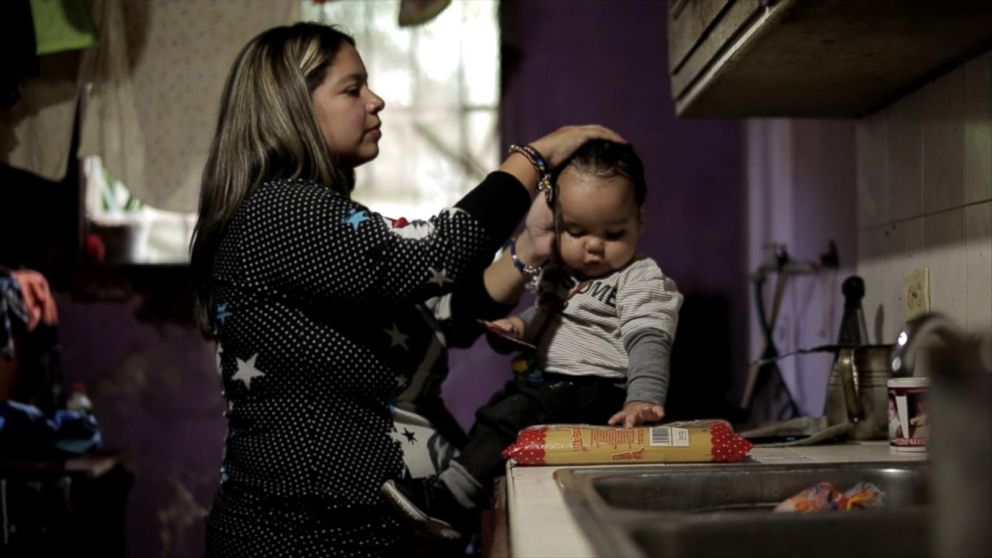 PHOTO: A young anti-government demonstrator at home with her son, Venezuela.