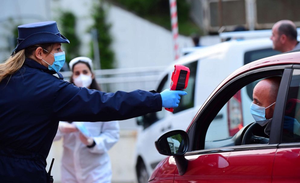 PHOTO: An employee checks the temperature of a driver who enters the FCA Mirafiori plant as it resumes its operations after closure during a nationwide lockdown amid the novel coronavirus outbreak in Turin, Italy, on April 27, 2020.