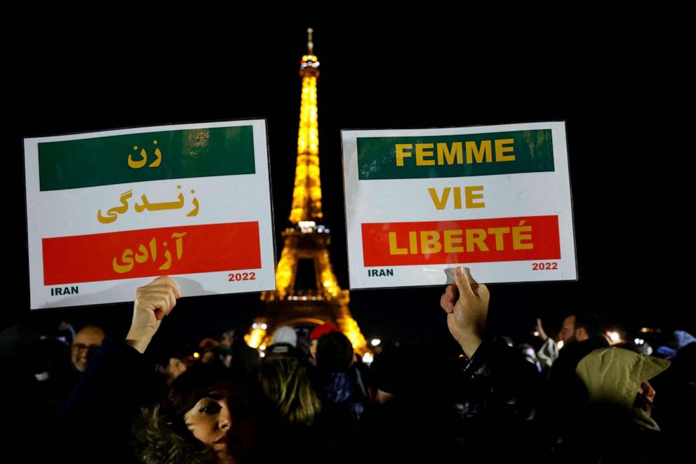 PHOTO: Protesters hold placards with the slogan "Woman. Life. Freedom." during a gathering on the Trocadero Esplanade to attend the slogan's display on the Eiffel Tower, in Paris, on Jan. 16, 2023.