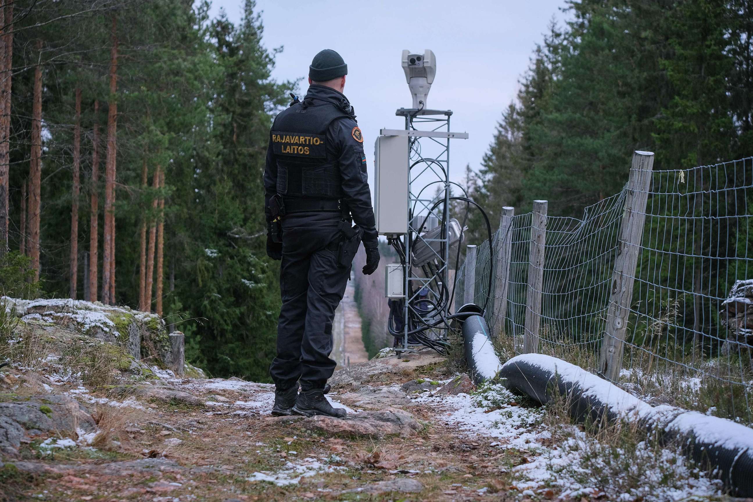 PHOTO: A border guard officer stands near a fence marking the boundary between Finland and the Russian Federation near the border crossing of Pelkola, in Imatra, Finland, Nov. 18, 2022.